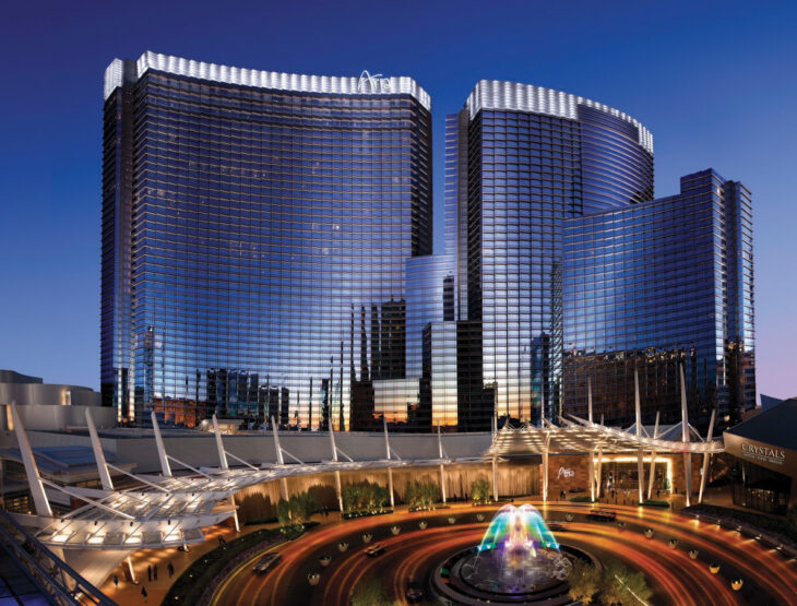 a large building with a fountain in front of it with Aria Resort and Casino in the background