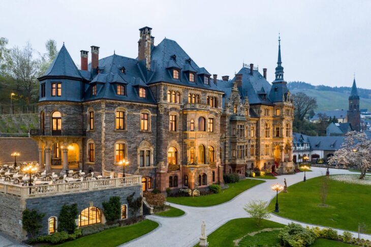 a large stone building with a walkway and lawn