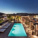 a pool on a rooftop with a city in the background